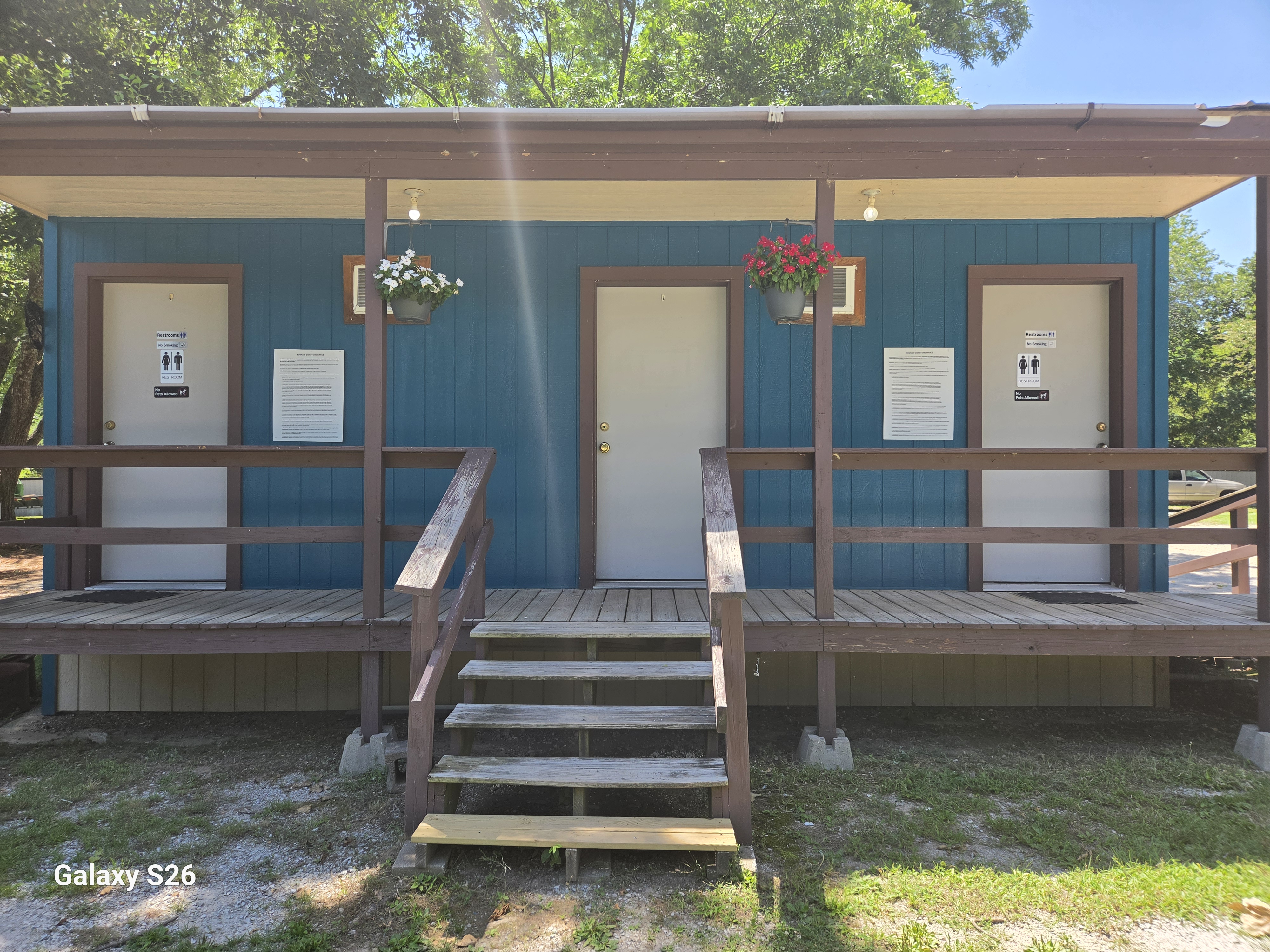 Restroom and bath house building at Bigfoot Base Camp RV Park with covered porch